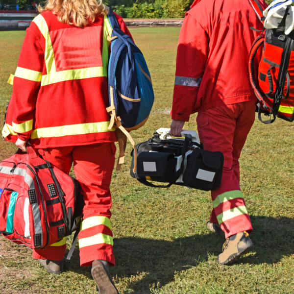 Ambulance staff with medical equipment on a sport track